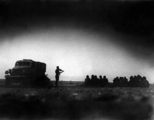 During an outdoor church service a British chaplain plays violin for the HQ staff of the British 8th while they sing traditional songs somewhere around El Alamein, Aug 1942. rw